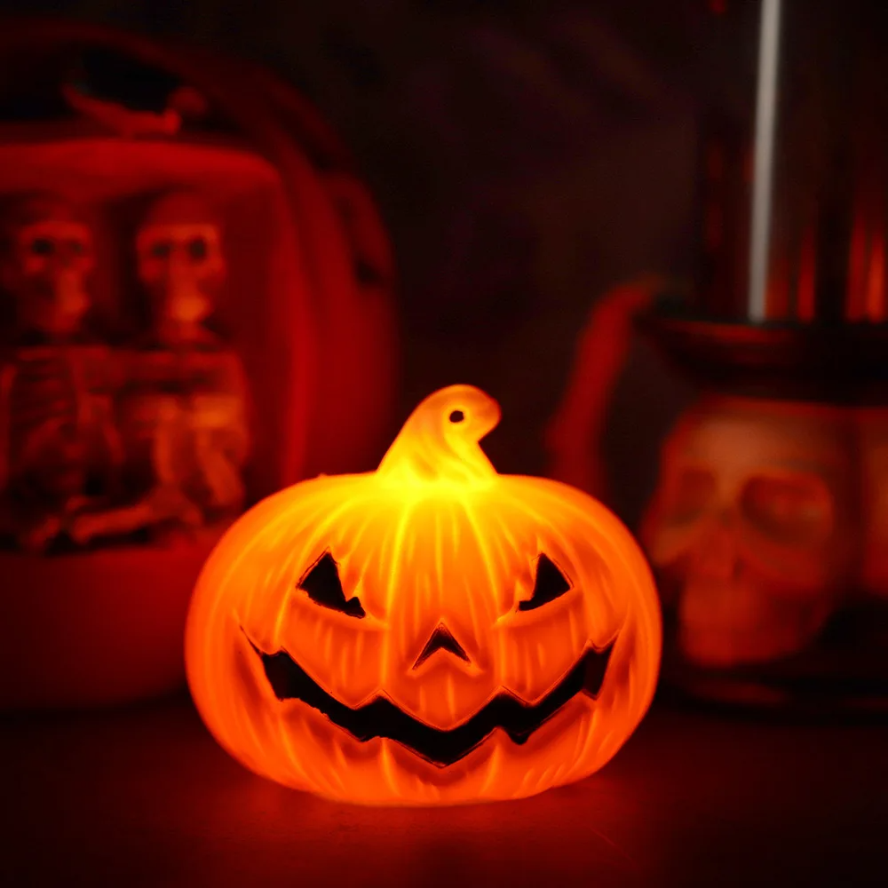 Farol calabaza de Halloween LED encendido iluminando en la oscuridad con decoración temática