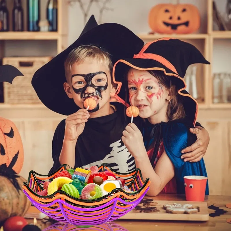 Niños disfrazados de Halloween sosteniendo paletas junto a cesta telaraña de golosinas