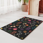 Tapete antideslizante e impermeable negro con ilustraciones multicolor para comedero de mascotas.